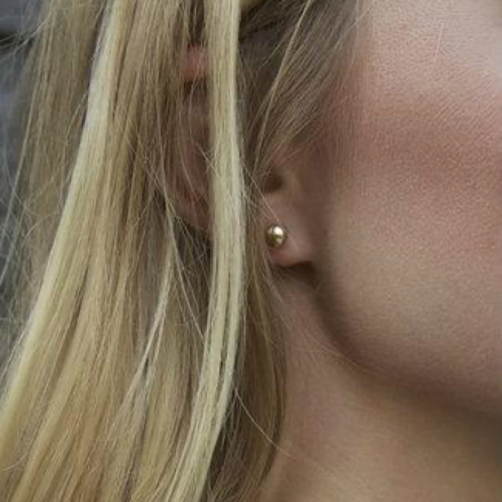 enewton Classic 6mm Ball Stud Earrings in Gold worn in an ear