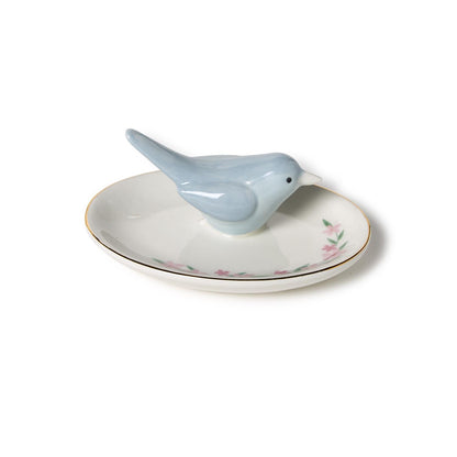 Blue bird ring holder on a white dish