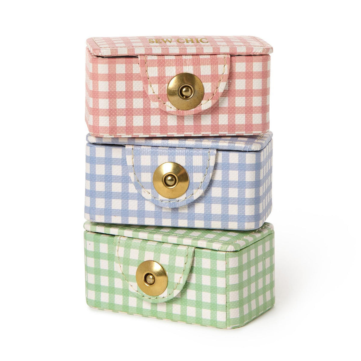 Three gingham mini sewing kit boxes stacked in pink, blue and green with gold snap closures