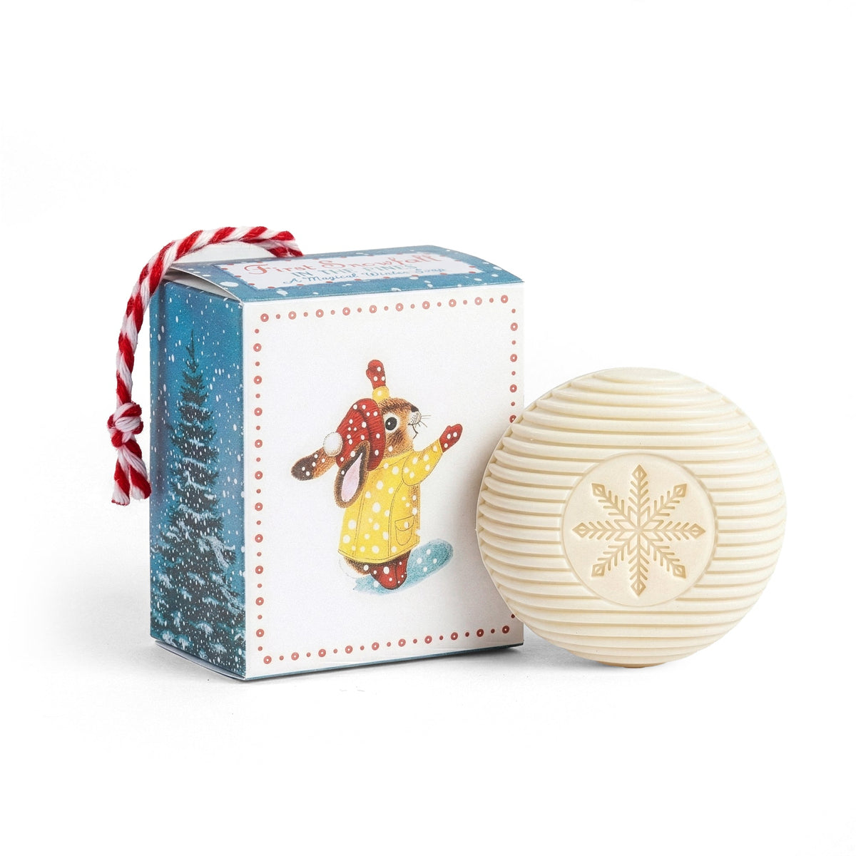 First Snowfall in the Pines hanging box soap - illustrated winter gift box with red and white striped cord hanger beside a snowflake-embossed round soap