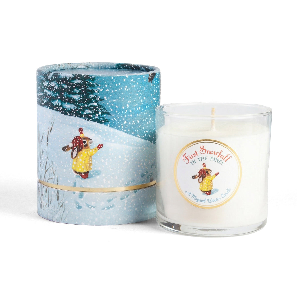 First Snowfall in the Pines 10 oz soy candle in clear glass beside its illustrated snowy pine forest gift sleeve