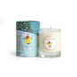 First Snowfall in the Pines 3 oz soy votive candle in clear glass beside its illustrated winter gift tube