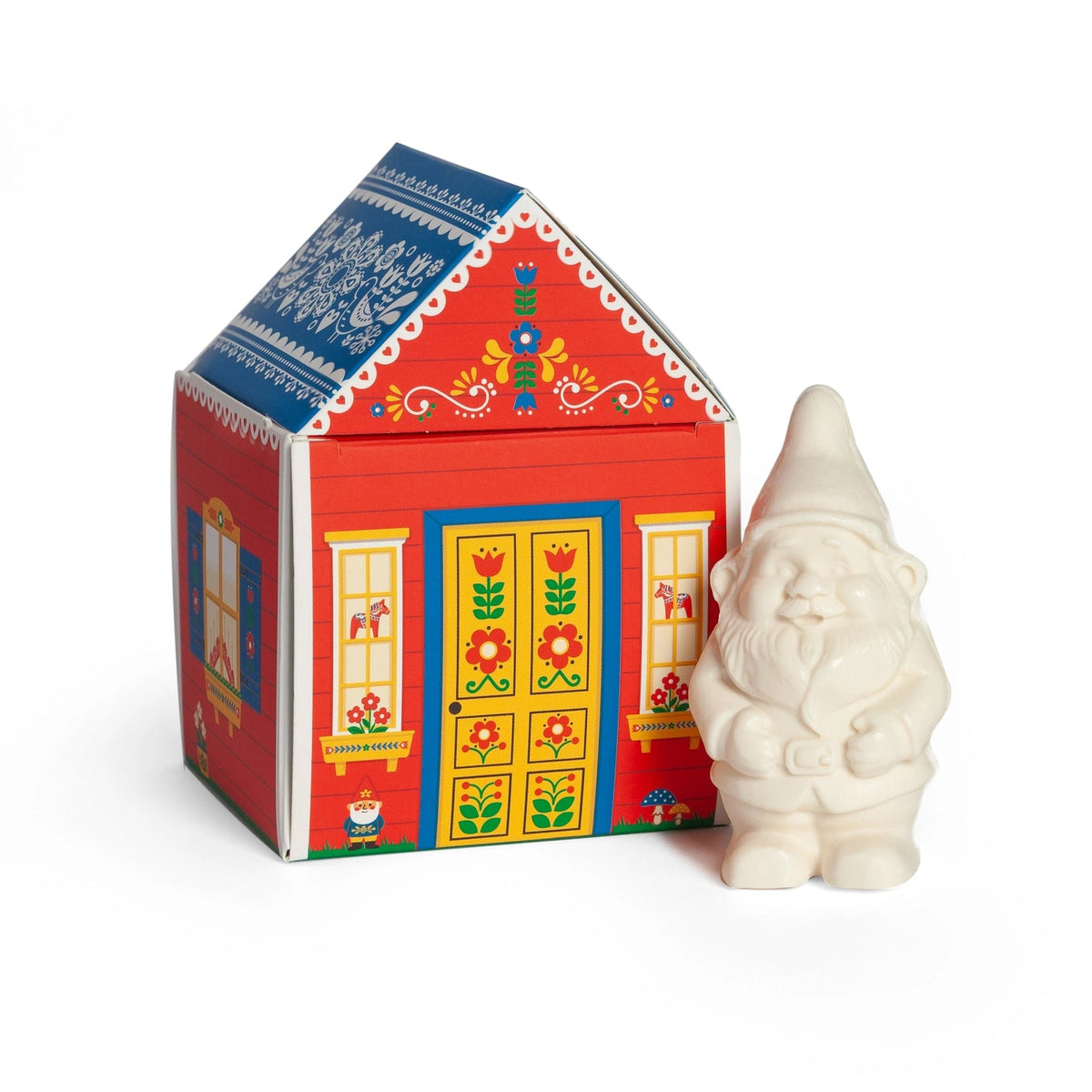 The Gnome's Cottage Soap - gnome-shaped white bar soap beside its illustrated red and blue Nordic folk art cottage box