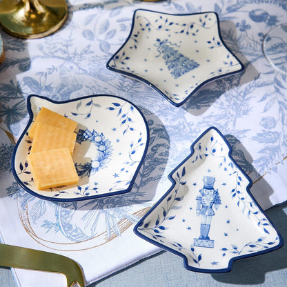 Blue and white Christmas tidbit dishes holding cheese and crackers on a holiday table
