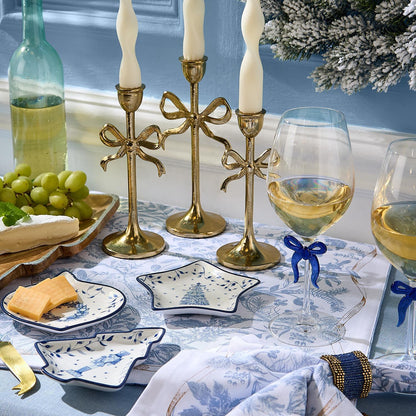 Blue and white tidbit dishes on a holiday tablescape with gold candlesticks