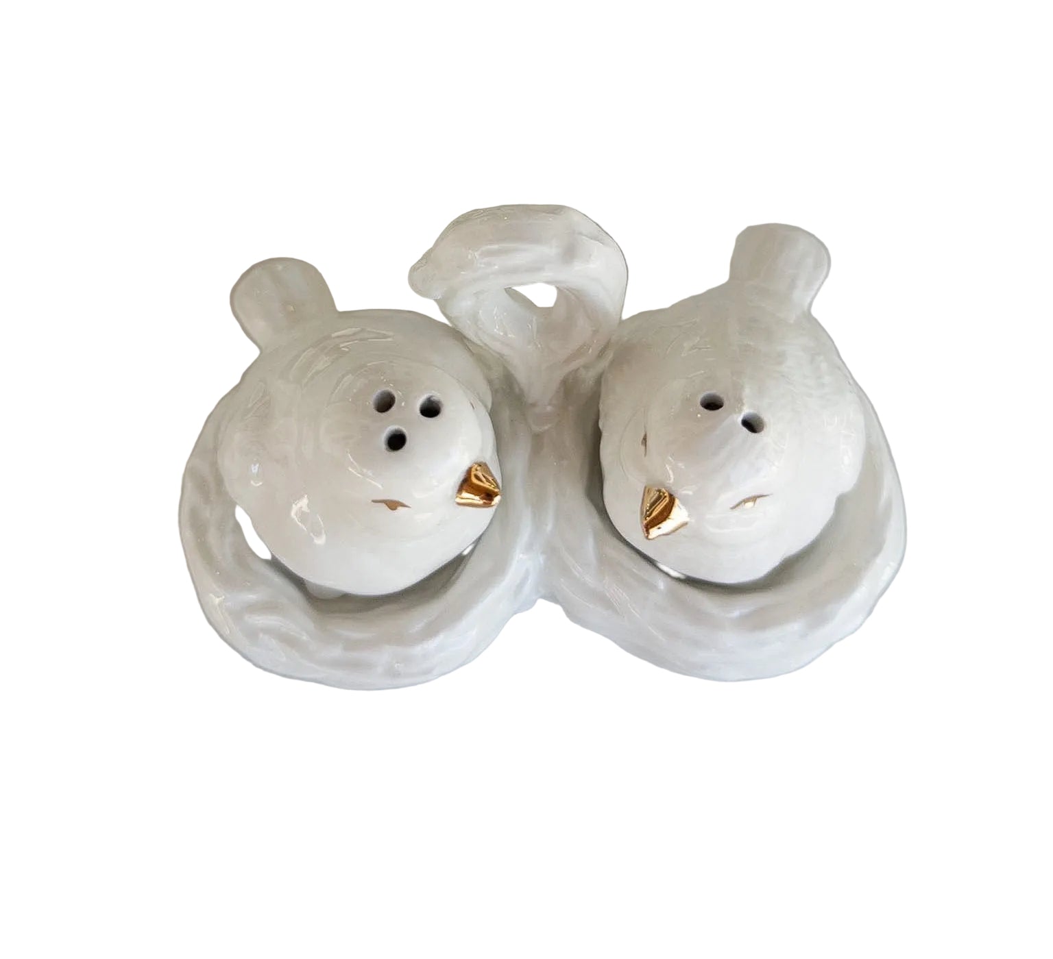 Two white ceramic bird-shaped salt and pepper shakers on a light surface.