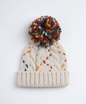 Cream cable knit pom pom beanie with colorful stitching