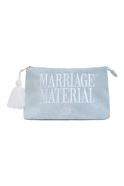 A light blue velvet pouch with white embroidered text reading 'MARRIAGE MATERIAL' and a white tassel zipper pull, shown on a plain white background.