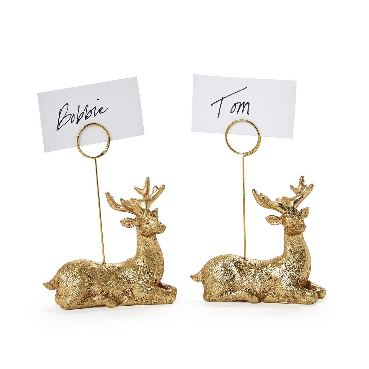 Two golden deer place card holders holding handwritten name cards